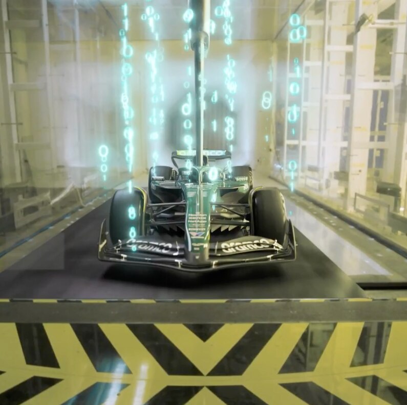 Aston Martin F1 car in a wind tunnel with digital airflow simulation