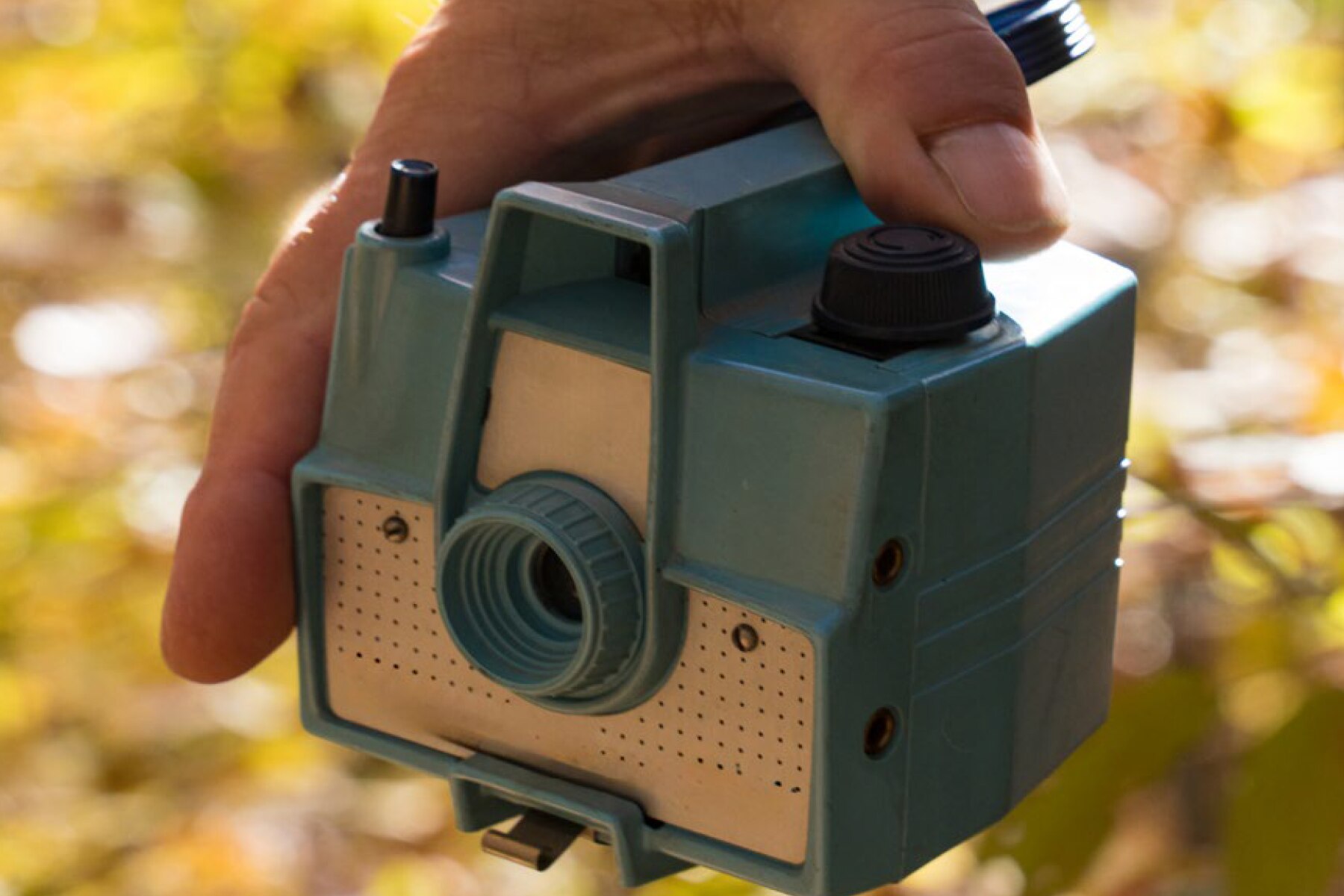 Hand holding a retro-style plastic camera