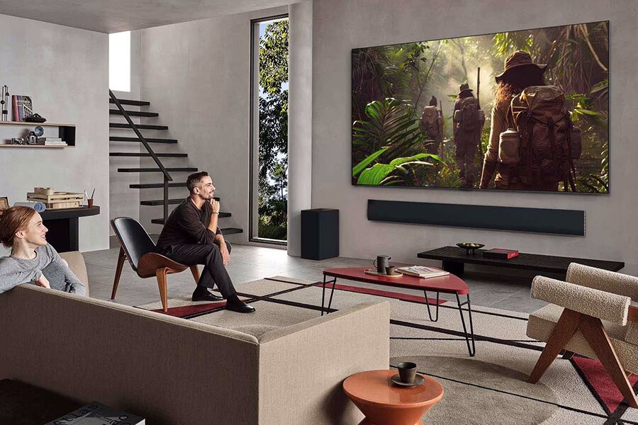 Couple enjoying cinematic visuals on a large LG OLED evo TV in a modern living room.