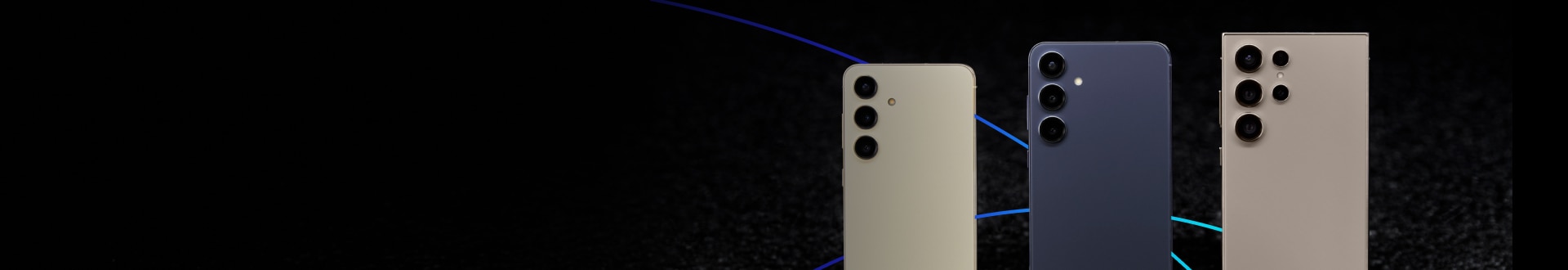 Three Samsung Galaxy S24 phones in cream, navy, and beige on a black surface.