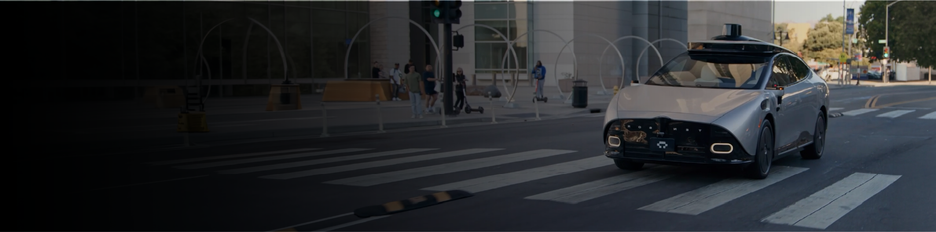 Autonomous vehicle driving through a city intersection.