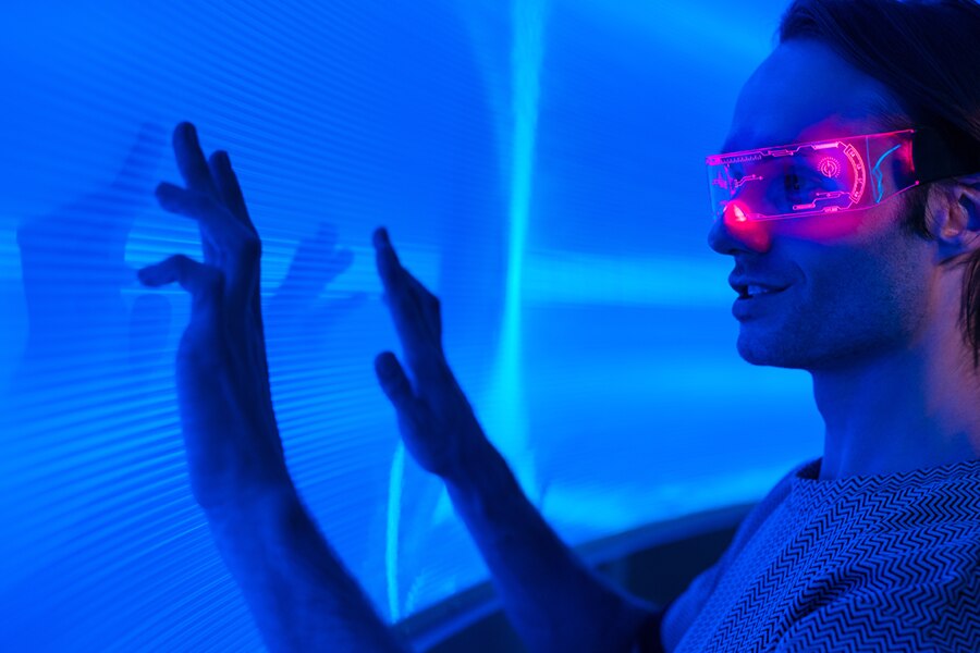 Man wearing AR/VR glasses interacting with a digital screen.