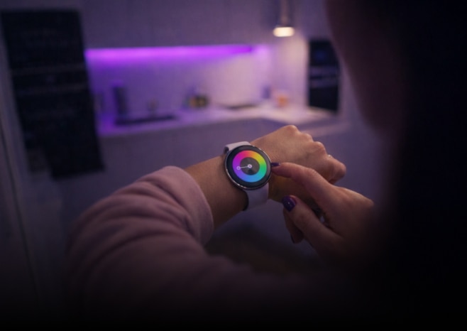 Wearables embedded - Person interacting with a smartwatch in a connected home environment.