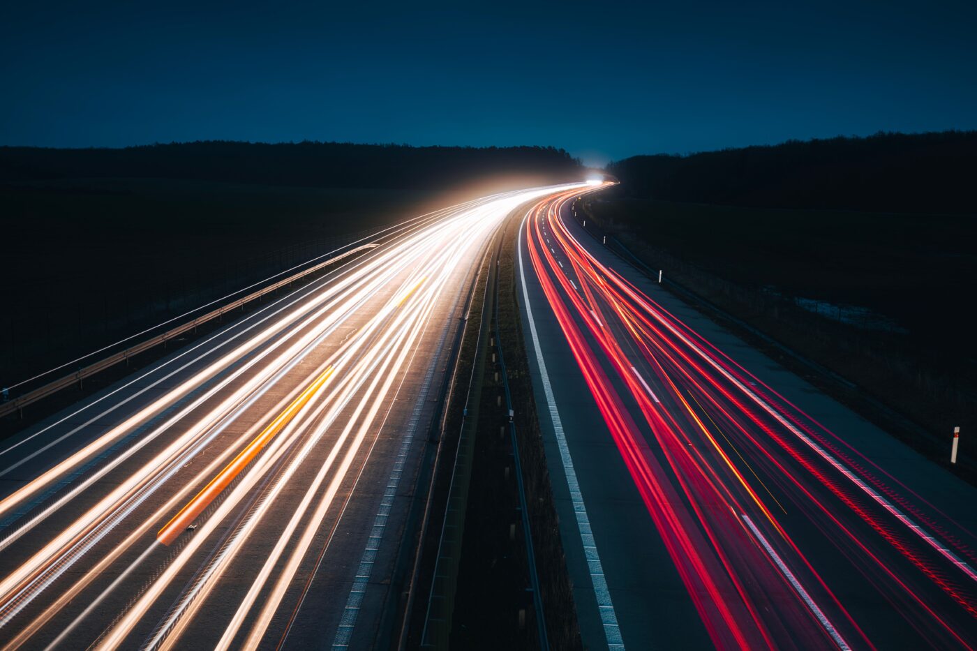 Highway at night with long-exposure light trails from traffic