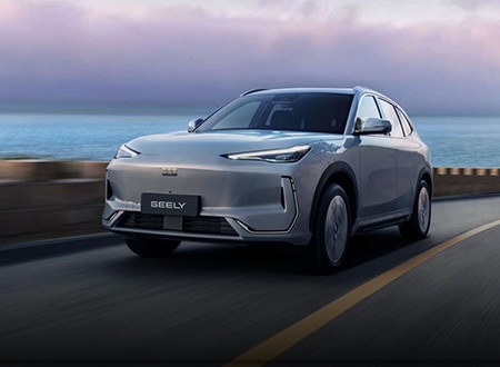 Geely electric vehicle driving along a coastal road.