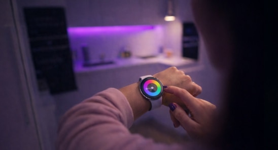 Wearables - Person interacting with a smartwatch in a connected home environment.
